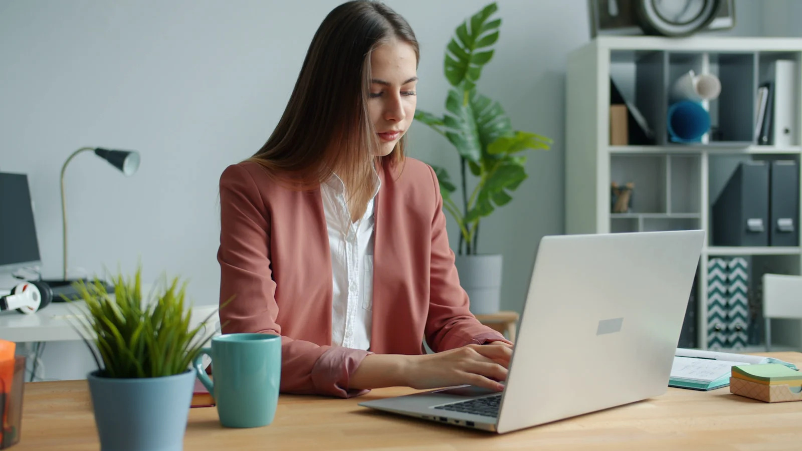 A woman is sitting at a table in front of her laptop